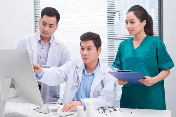 Three Doctors Discussing Patient Files Office — Stock Photo, Image