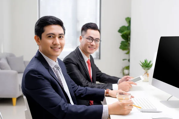 Businessmen with colleges smiling in office