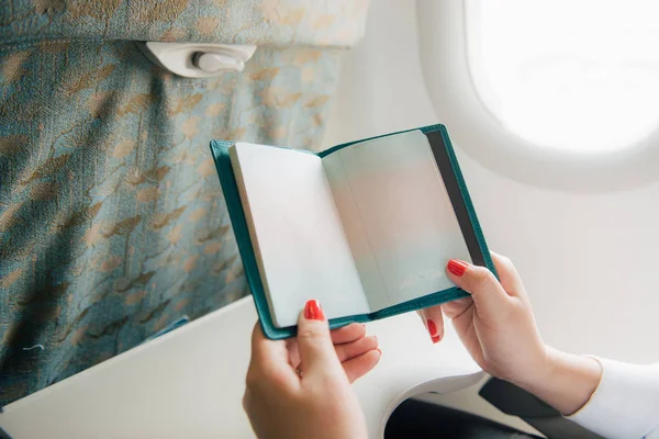 Airplane vacation journey. Man with passport and ticket sitting next to window