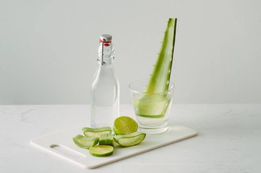 beyaz arka plan üzerinde şişe cam taze aloe vera yaprakları ve aloe vera suyu