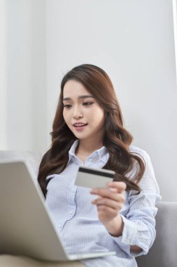 Güzel bir yaşam kanepe olmadan evden alışveriş yaparken laptop ve banka kartını kullanarak