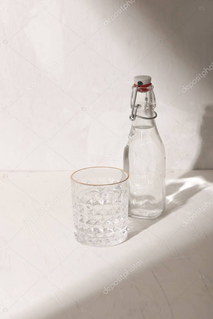 Glass bottle of water with drinking glass