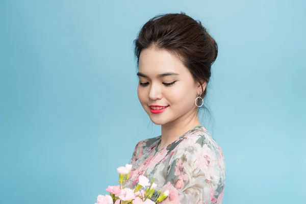 Mavi Arka Plan Üzerinde Çiçek Buketi Ile Büyüleyici Asya Kadın — Stok fotoğraf