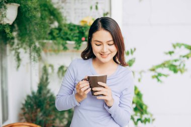 Kadınlar balkonda kahvelerini yudumlarlar. 
