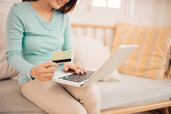 Female customer buying goods in Internet store, using credit card for online shopping at home