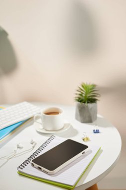 Üst görünüm ofis masa masası. Beyaz arka plan üzerinde cep telefonu ve ofis malzemeleri ile çalışma alanı. 