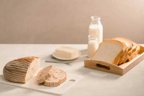 Хлеб Тарелке Держатель Окружении Масла Молока Белом Столе Крупным Планом — стоковое фото