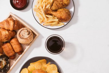 Taze pişmiş ekmeği, büyük hamburger, kızarmış gevrek tavuk ve patates kızartması beyaz tablo - sağlıksız yiyecek konsepti