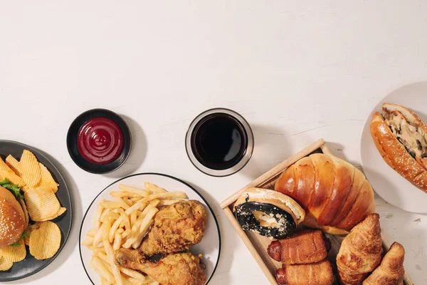 快餐和不健康的饮食概念 关闭快餐小吃和可乐饮料在白色桌上 — 图库照片