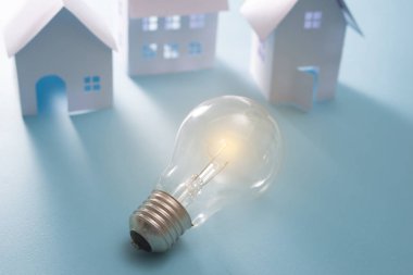 Mavi arka plan üzerinde ampul ile Ev Enerji
