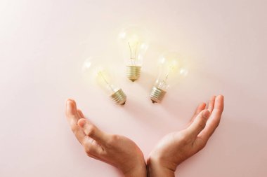 ampul ile kalp elinde yeşil dünya - pembe arka plan