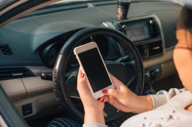 Araba trafik sıkışıklığı sırasında boş ekran akıllı telefon tasarım amaç için kullanarak kadını sürücüsü .