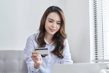 Güzel bir yaşam kanepe olmadan evden alışveriş yaparken laptop ve banka kartını kullanarak.