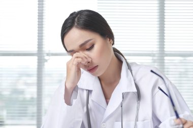 Umutsuz kadın doktor ofisinde oturuyor.