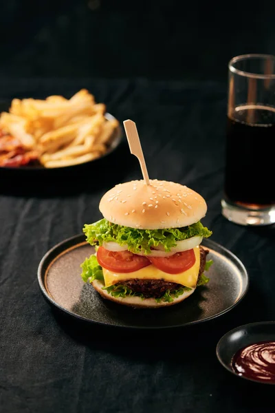 Unhealthy concept. unhealthy food: Burger, sauce, potatoes, cola.