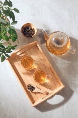 Sıcak çay bardakta. Ahşap bir tepsi üzerine yerleştirilmiş.