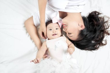 Genç anne ve evde yatakta şirin bebek