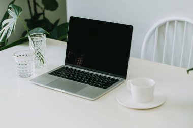 not defteri ve dizüstü bilgisayar ile beyaz ofis masası
