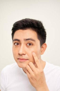 Onun yüzünde acnes arayan genç adam fotoğrafı kapatın