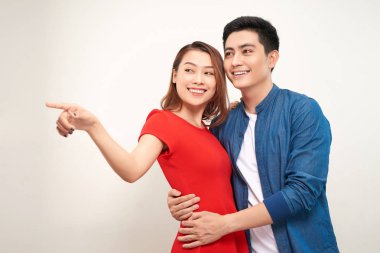 Kadın bir şeye işaret etti. İki aşık da kameraya bakıyor. Beyaz arka planda yalıtılmış