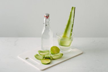 beyaz arka plan üzerinde şişe cam taze aloe vera yaprakları ve aloe vera suyu