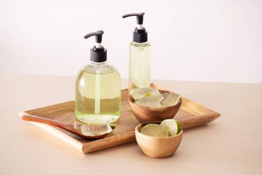 Aloe vera yaprağı, soyulmuş aloe ve aloe jel veya infüzyon şişeleri dolu kase