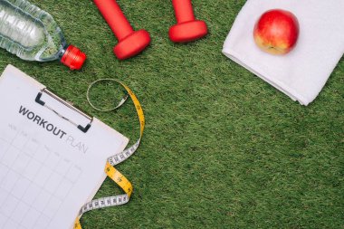 Çimlerin üzerinde kağıt ve spor malzemeleri.