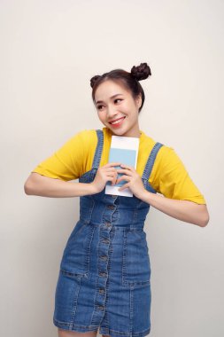 Beyaz arka plan üzerinde izole pasaport ve bilet tutarken kameraya bakan mutlu Afrikalı Amerikalı kadının Görüntü closeup