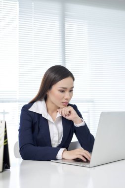 Neşeli çalışan gözlük tutuyor ve parlak bir gülümseme ile dizüstü ekran bakıyor