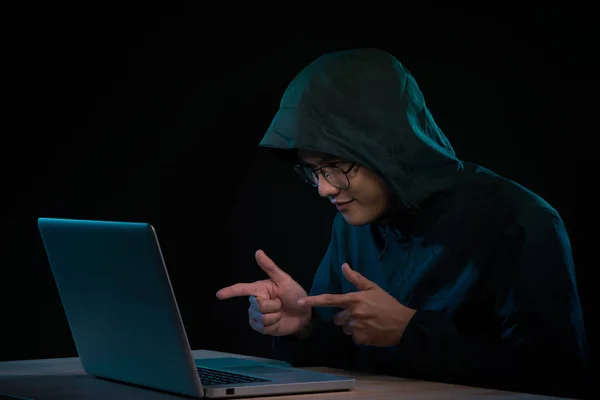 成功的男性黑客在笔记本电脑前摆姿势 紧握拳头 身着黑色衣服 欢欣鼓舞地整理不良数据病毒 — 图库照片
