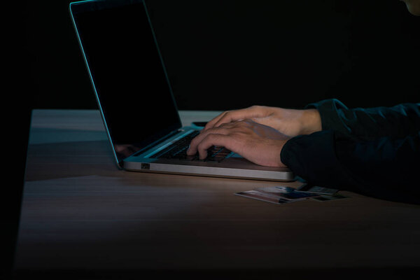 Man working on laptop in dark room