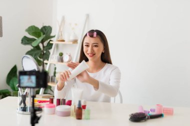 Sosyal medyada paylaşmak için kamera ile genç kadın profesyonel güzellik vlogger veya Blogger kayıt kozmetik makyaj öğretici