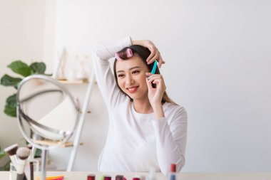 Saç eğitimi. Onun güzellik blog için bir öğretici filme iken Asyalı kadın saçlarını fırçalamak ve hoş gülümseyen