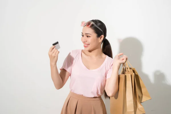 쇼핑백을 들고와 카메라를 카드를 보여주는 여자의 초상화 — 스톡 사진
