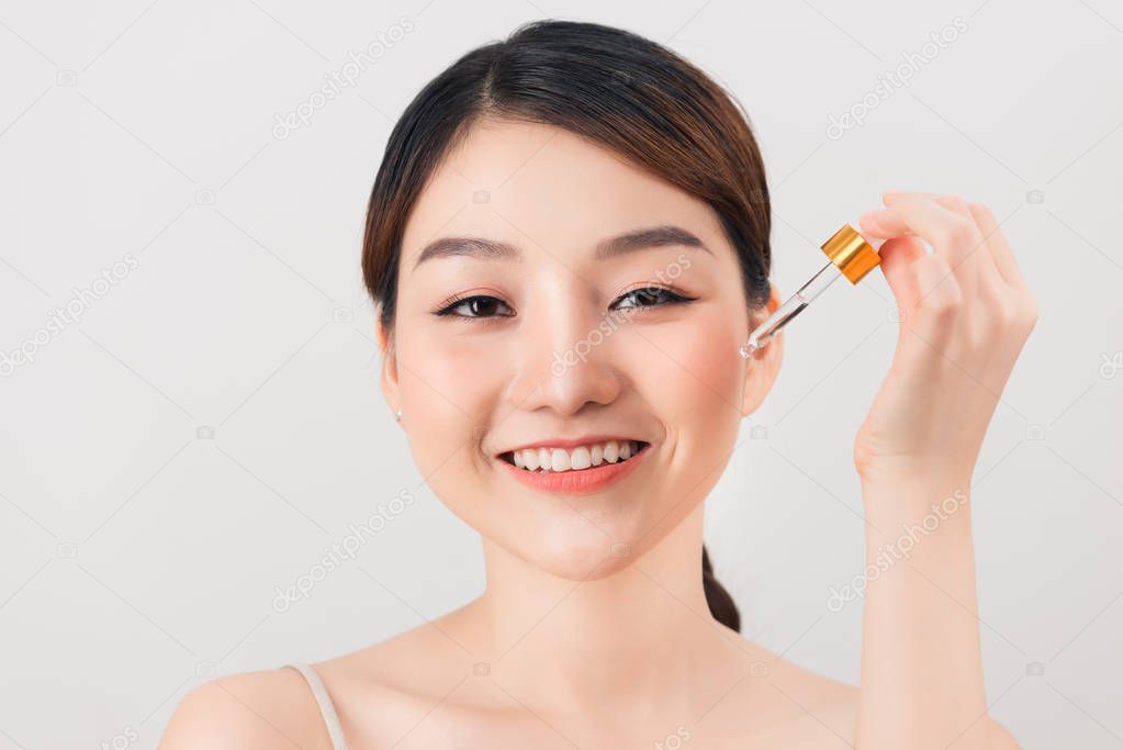 Photo of a beautiful young pretty asian woman with healthy skin take care of her skin with cosmetics.