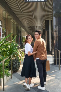 Güzel, genç bir çift alışveriş torbaları taşıyor ve birlikte eğleniyorlar.. 