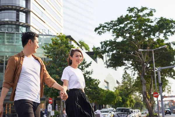 Young Asian couple going out for shopping on Le Loi road in Hochiminh city, Vietnam