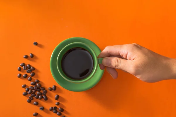 Taking Green Cup Coffee Coffee Beans Orange Background — Stock Photo, Image