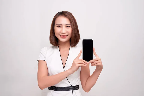 アジアの美しいビジネスウーマンが白い携帯電話を持ち 白い携帯電話を見せている — ストック写真