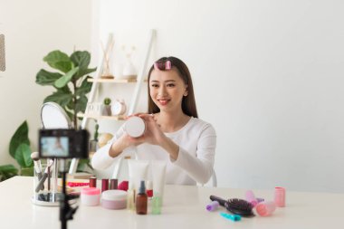 Sosyal medyada paylaşmak için kamera ile genç kadın profesyonel güzellik vlogger veya Blogger kayıt kozmetik makyaj öğretici