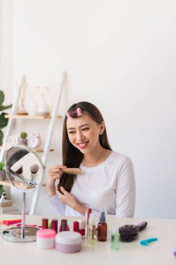 Saç eğitimi. Onun güzellik blog için bir öğretici filme iken Asyalı kadın saçlarını fırçalamak ve hoş gülümseyen
