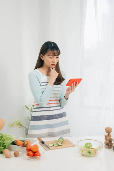 Mujer Joven Con Verduras Sonriendo Mientras Usa Teléfono Móvil Cocina — Foto de Stock