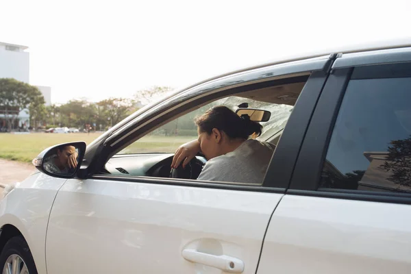 Stressed woman driver sitting inside her car