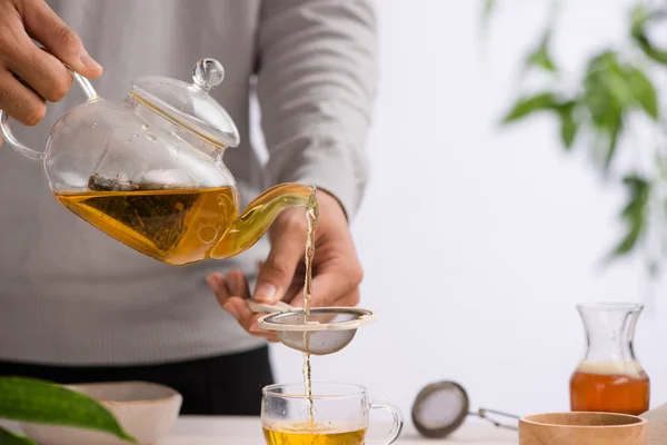 木製テーブルの上に紅茶のティーポット カップから注がれる — ストック写真