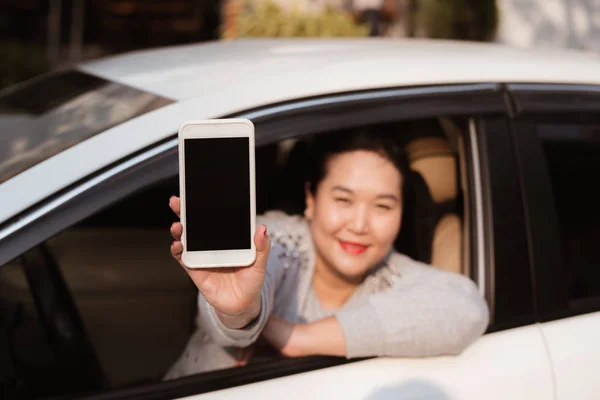 有吸引力的年轻妇女在汽车显示智能手机与空白屏幕 — 图库照片