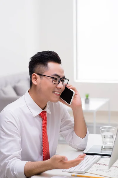 Szczęśliwy Młody Biznesmen Rozmowy Telefon Komórkowy Pomocą Komputera Biurze — Zdjęcie stockowe