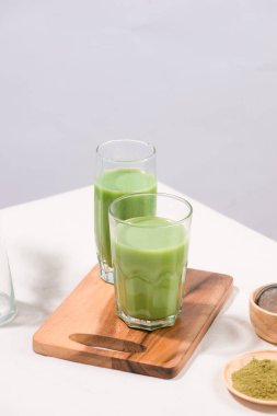 Matcha yeşil çay buzlu latte veya kokteyl beyaz arka plan üzerinde uzun cam
