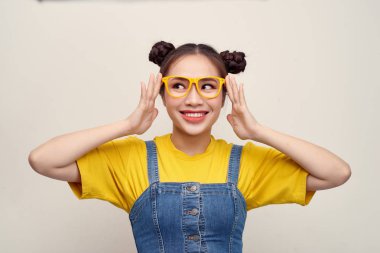 Güzel Asyalı kadın pantolon salopet giyen ve gözlük ayarlama saç iki çörekleri vardır 