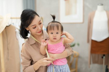 Birlikte çalışıyoruz. Genç güzel tasarımcı onu iş yerinde onun bebek kız yanında duran
