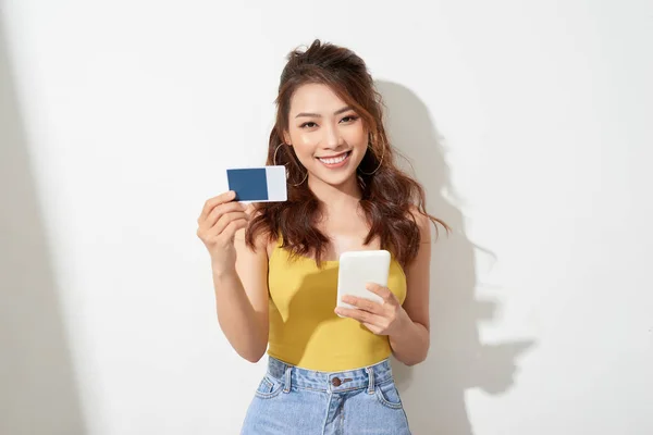 Asian young woman holding a card and mobile phone